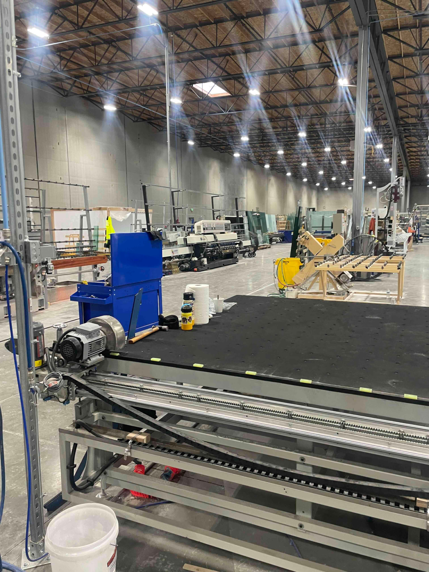 Cutting table and edge grinder. Cutting our own glass is what makes matching a legacy sightline possible instead of approximating it with a stock size.