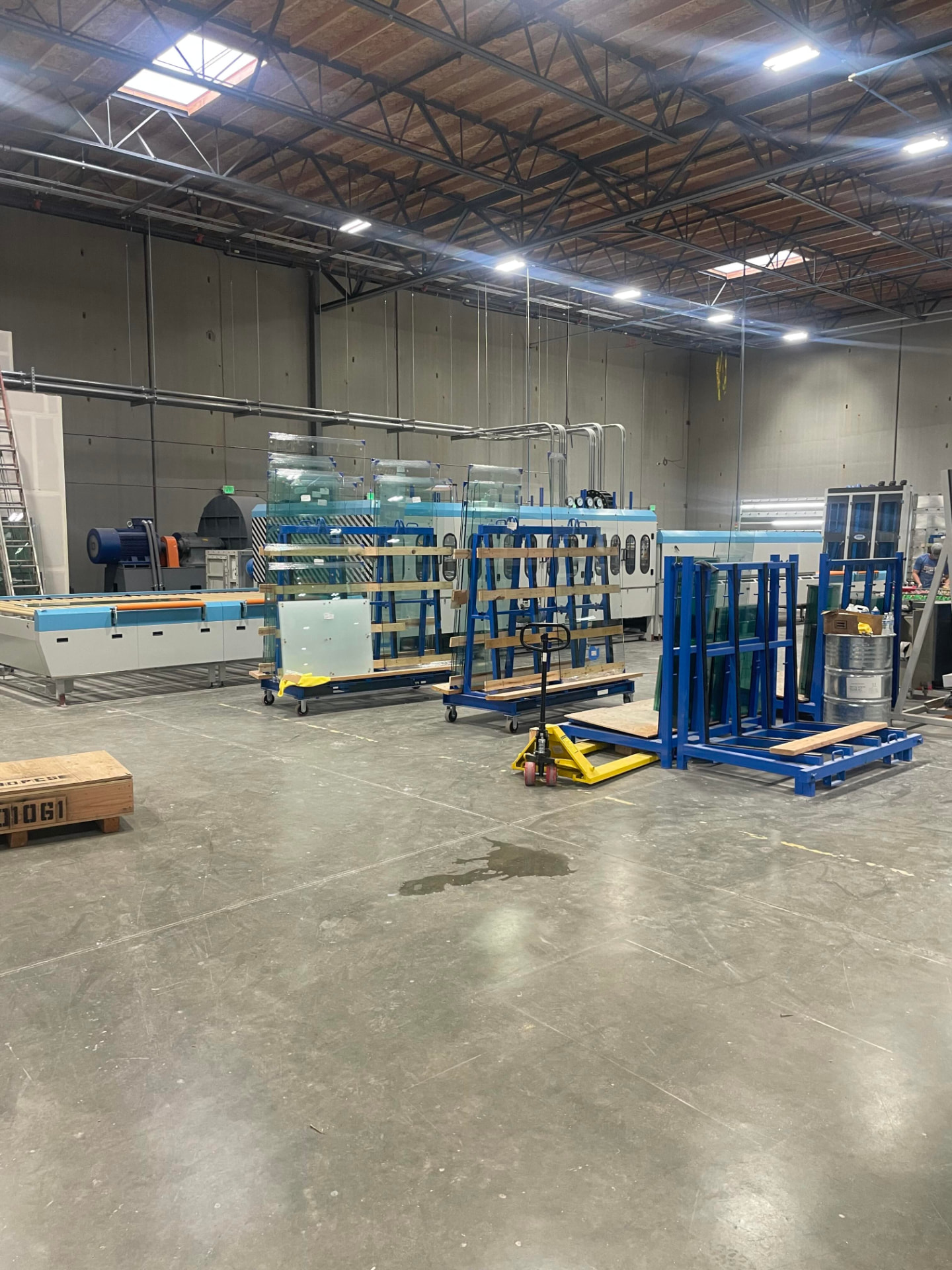 Our insulated glass shop. Lites are racked, washed, and sequenced before assembly so each restored sash receives a unit built to its own measured opening.
